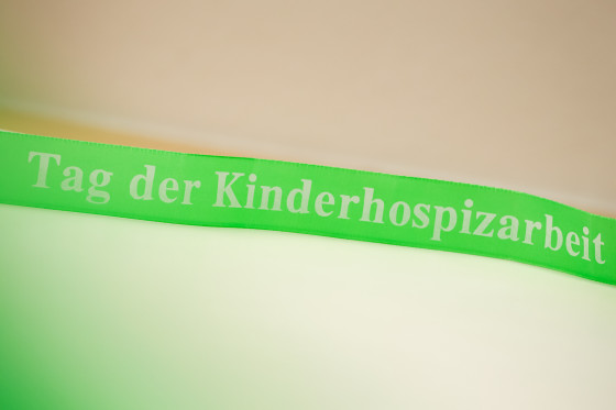 grünes Band mit Aufschrift "Tag der Kinderhospizarbeit"