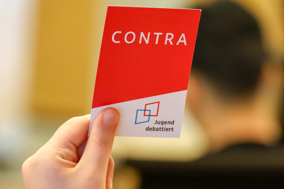 Hand hält Schild "Contra" hoch