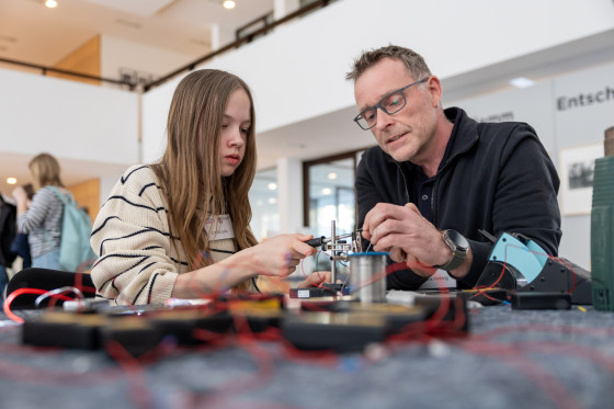 Mann zeigt Mädchen eine Elektroarbeit