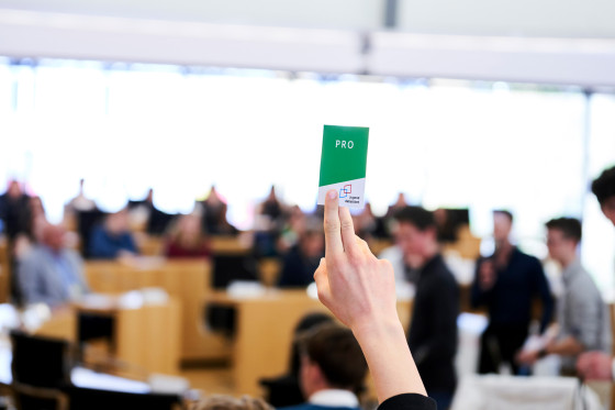 Hand hält Karte mit "Pro" hoch