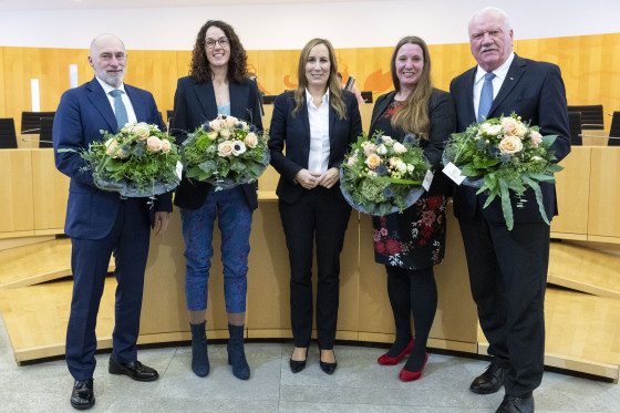 Präsidentin und Vizepräsidenten mit Blumensträußen