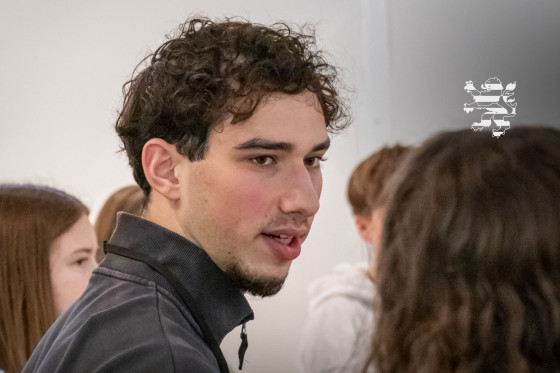 Ein Teilnehmer des Begegnungsprojekts "Meet a Jew" ist im Bild zu sehen. Er spricht mit einer Schülerin.