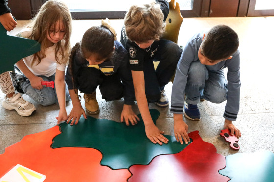Kinder fügen ein Bundesländer-Puzzle zusammen