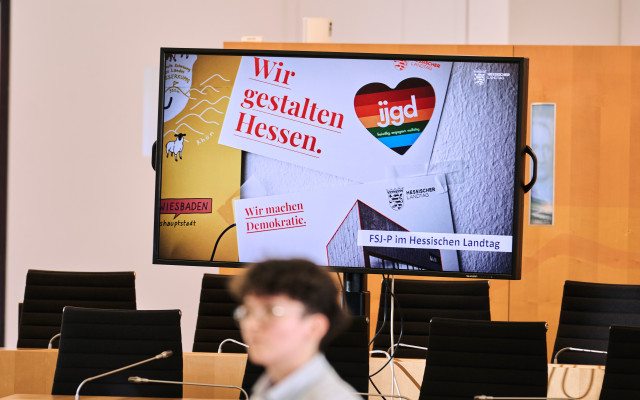 Landtags-FSJlerin Charlotte vor einem Bildschirm mit Werbung für das FSJ